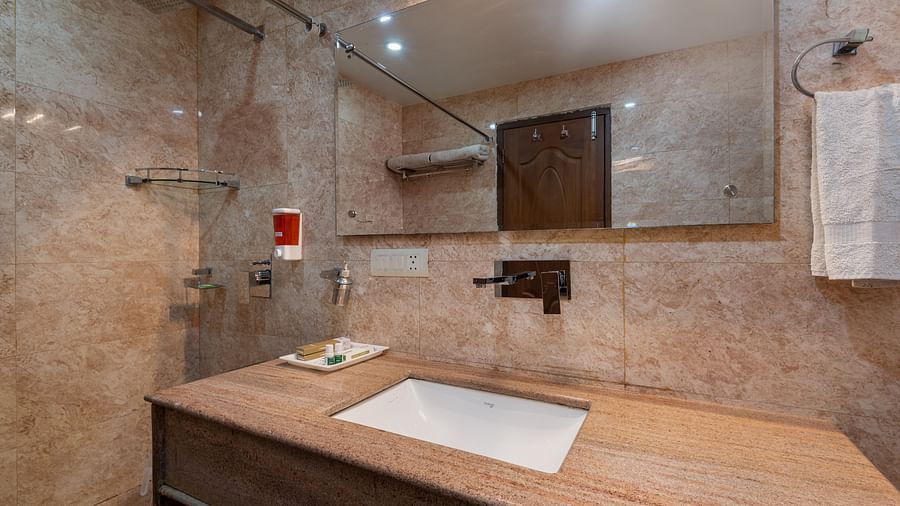 Super deluxe washroom featuring a wash basin and a mirror at DLS Hotels The Rock Castle.